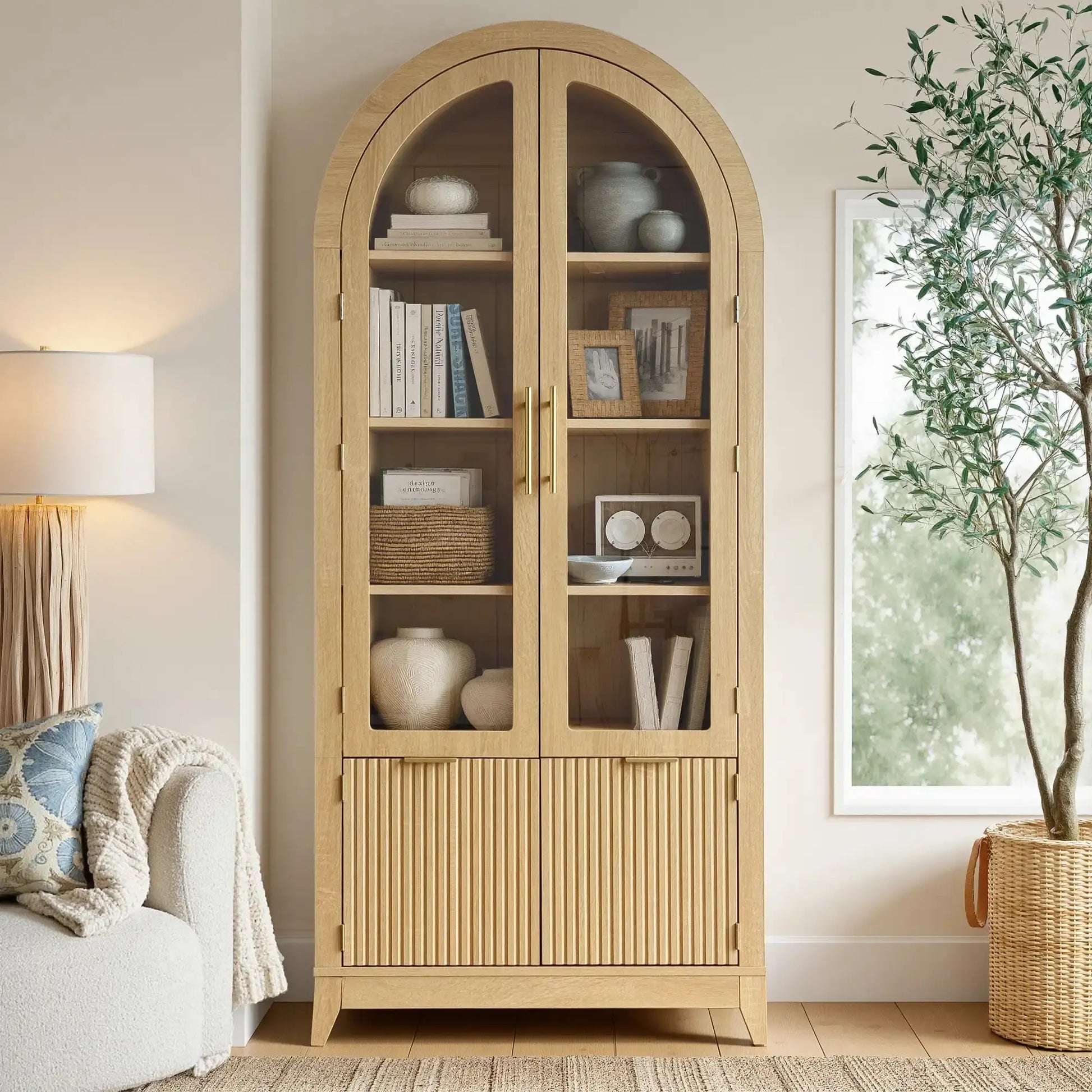 Win2Win Tall Arched Cabinet with Glass Doors, Oak Storage Cabinet with Fluted Doors in a living room, paired with a sofa, floor lamp, and large green plant